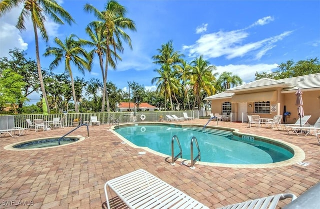 pool with a community hot tub, a patio area, and fence