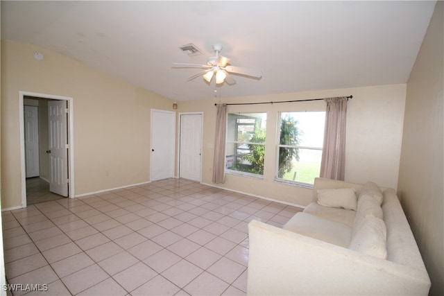 living room featuring lofted ceiling, light tile patterned flooring, and ceiling fan