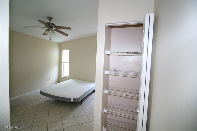 bedroom with ceiling fan and tile patterned flooring