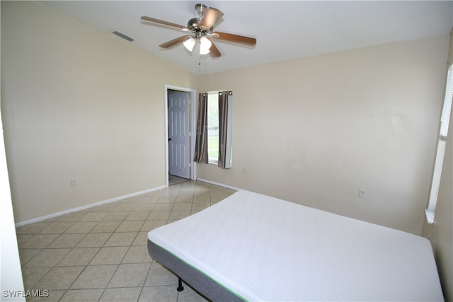 bedroom with vaulted ceiling, light tile patterned floors, and ceiling fan