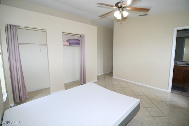 tiled bedroom with ceiling fan and ensuite bathroom