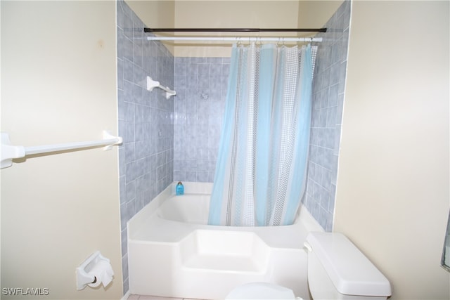 bathroom with shower / bath combination with curtain and toilet