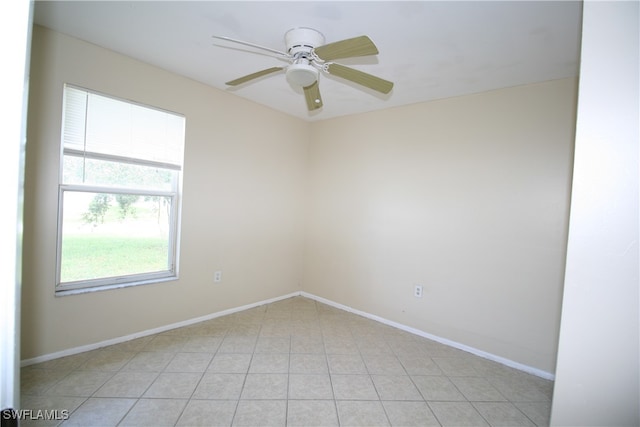 tiled spare room featuring ceiling fan