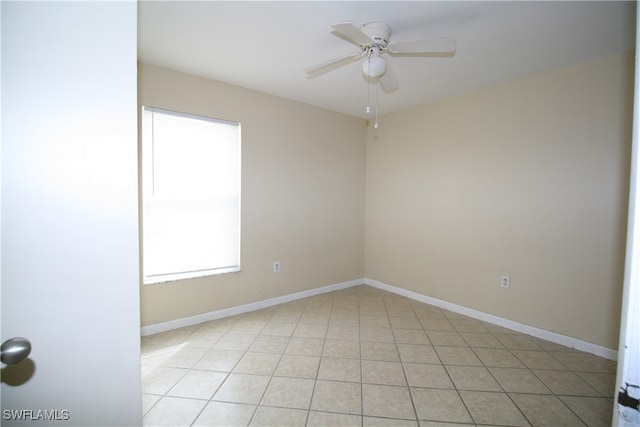 empty room featuring ceiling fan, a healthy amount of sunlight, and light tile patterned floors