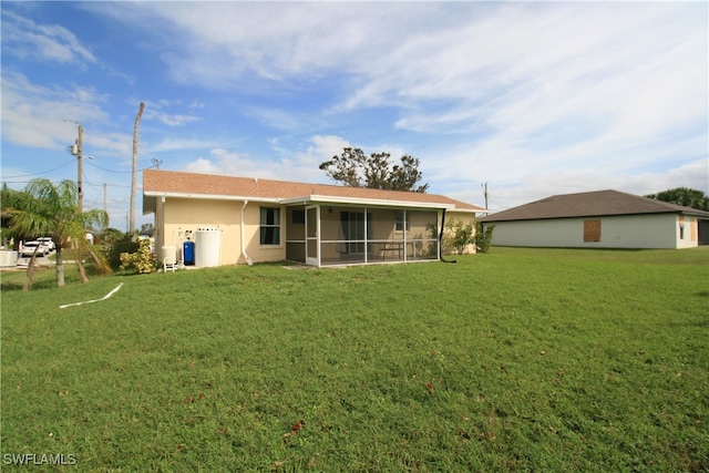 rear view of property with a lawn and a sunroom