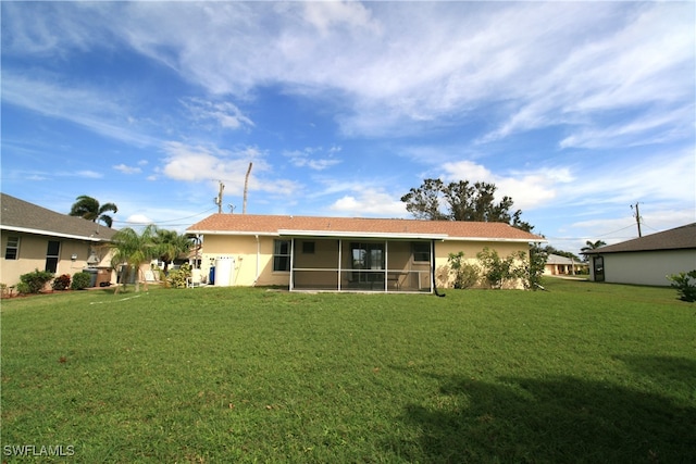 back of property with a yard and a sunroom