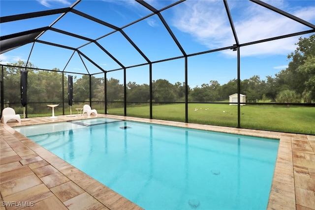 view of pool featuring glass enclosure and a lawn