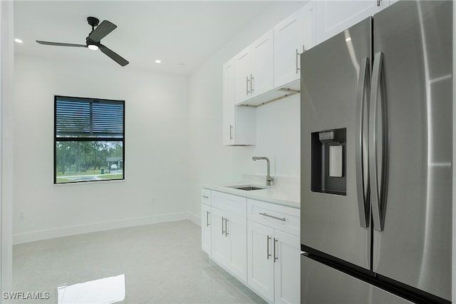 kitchen featuring sink, white cabinetry, stainless steel refrigerator with ice dispenser, ceiling fan, and light tile patterned floors