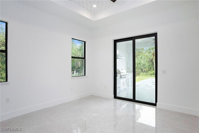 3660 4th Ave NE, Naples, FL 34120 - unfurnished room featuring baseboards, a tray ceiling, recessed lighting, and plenty of natural light