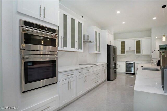 kitchen featuring appliances with stainless steel finishes, decorative backsplash, light stone counters, beverage cooler, and hanging light fixtures