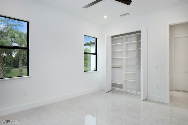 unfurnished bedroom with light tile patterned floors, ceiling fan, a closet, and multiple windows