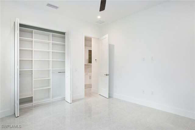 unfurnished bedroom featuring light tile patterned flooring, a closet, and ceiling fan