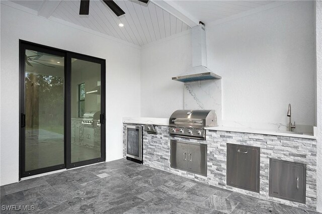 kitchen featuring ceiling fan, dark tile patterned floors, beamed ceiling, and premium range hood