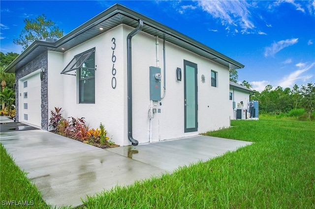 3660 4th Ave NE, Naples, FL 34120 - view of property exterior featuring stucco siding, a yard, and an attached garage