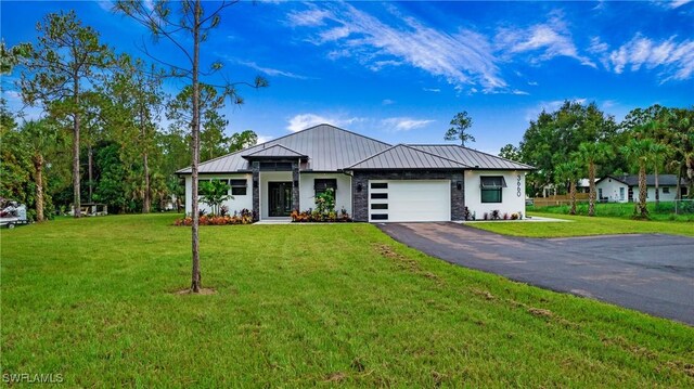 3660 4th Ave NE, Naples, FL 34120 - view of front of home featuring metal roof, a garage, a standing seam roof, a front lawn, and driveway