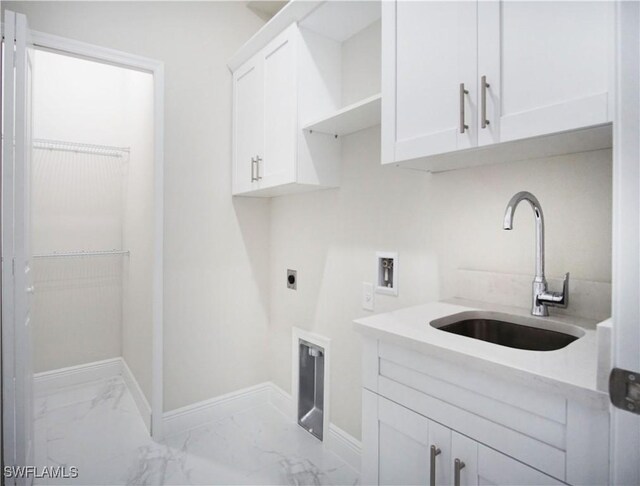 clothes washing area with hookup for an electric dryer, hookup for a washing machine, cabinet space, marble finish floor, and a sink
