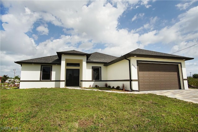 prairie-style house featuring a front yard, concrete driveway, an attached garage, and stucco siding