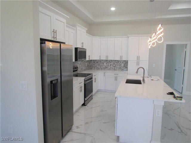 kitchen with tasteful backsplash, appliances with stainless steel finishes, marble finish floor, a sink, and a raised ceiling
