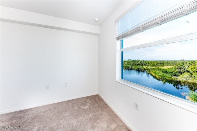 empty room featuring carpet flooring and a water view