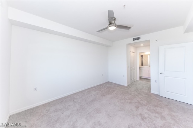 unfurnished bedroom with ceiling fan, light carpet, and ensuite bathroom