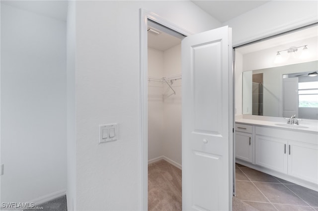 bathroom featuring tile patterned floors, vanity, and a shower with shower door