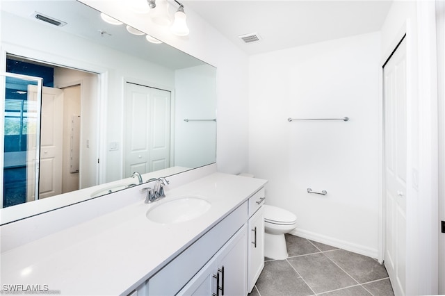 bathroom with tile patterned flooring, vanity, and toilet