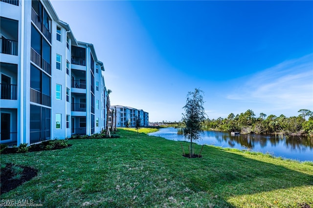 view of property's community with a lawn and a water view