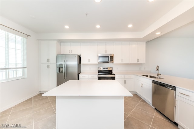 kitchen with sink, a center island, white cabinetry, appliances with stainless steel finishes, and light tile patterned floors