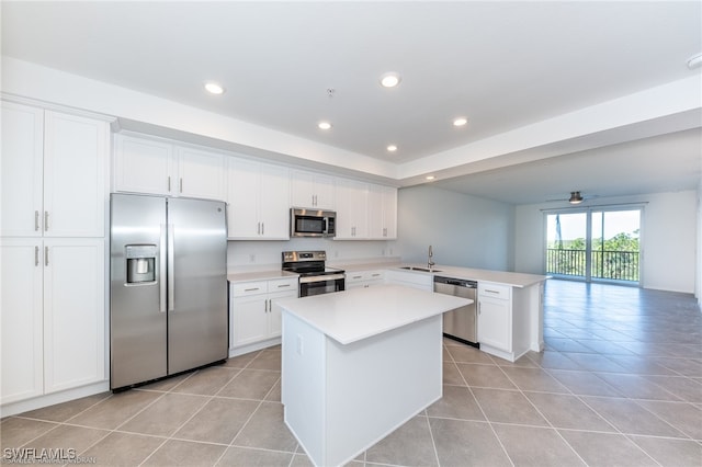 kitchen featuring a center island, white cabinets, appliances with stainless steel finishes, and light tile patterned floors