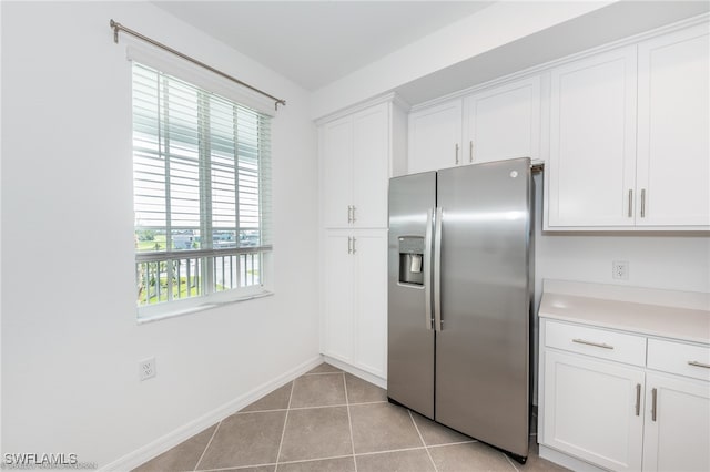 kitchen featuring white cabinets, light tile patterned flooring, and stainless steel refrigerator with ice dispenser