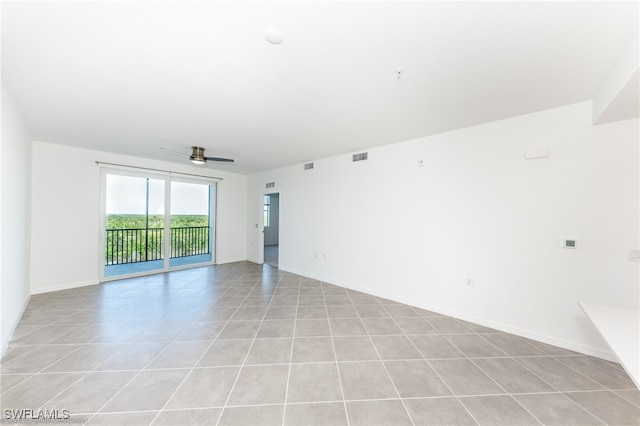 spare room with ceiling fan and light tile patterned floors