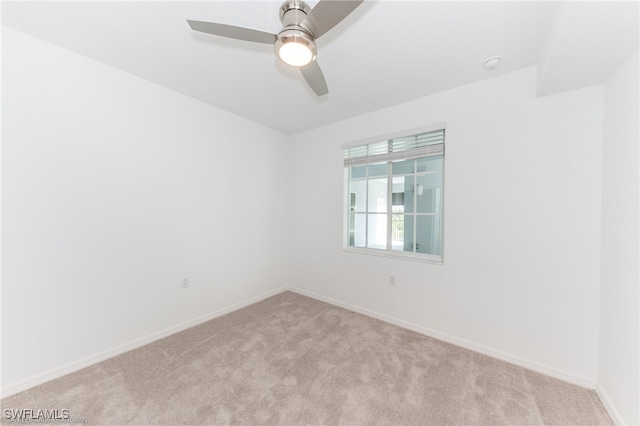 spare room featuring ceiling fan and light carpet