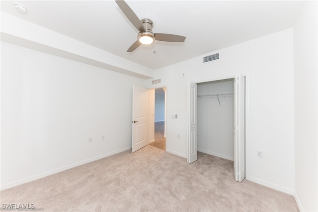 unfurnished bedroom featuring ceiling fan, a closet, and light carpet