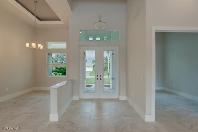 entrance foyer with french doors, a notable chandelier, and a high ceiling