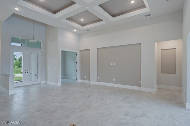 unfurnished room featuring french doors, coffered ceiling, a towering ceiling, and beamed ceiling