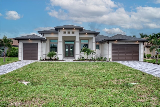 prairie-style home with french doors, a front yard, and a garage