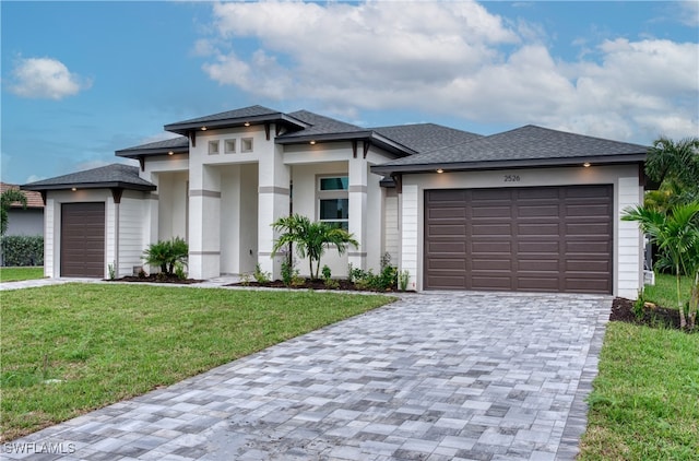 prairie-style home with a front yard and a garage