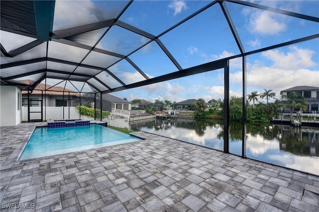 view of swimming pool with a patio, a water view, and a lanai