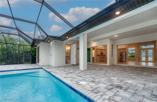 view of swimming pool featuring a patio and glass enclosure