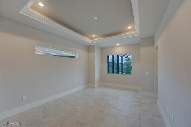 unfurnished room featuring a raised ceiling