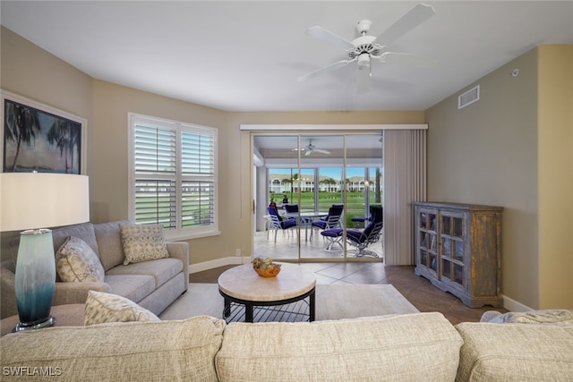 living room featuring baseboards, visible vents, a ceiling fan, and light tile patterned flooring