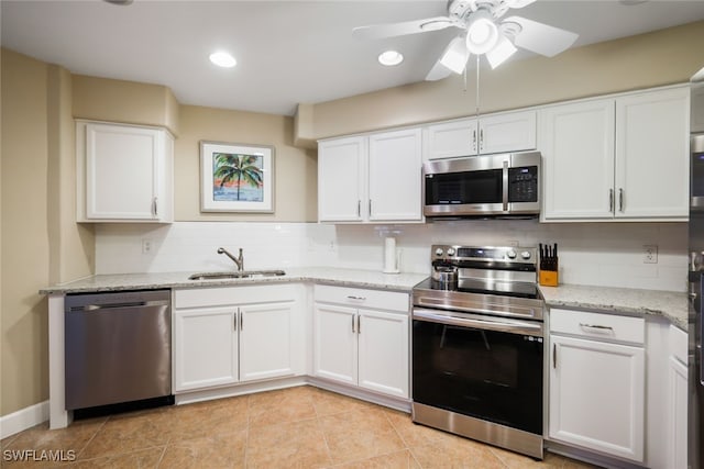 kitchen featuring appliances with stainless steel finishes, a sink, white cabinetry, and decorative backsplash