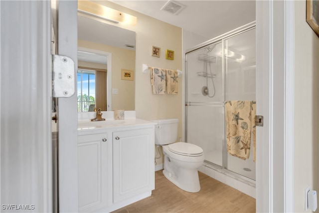 bathroom featuring toilet, a shower with door, and vanity