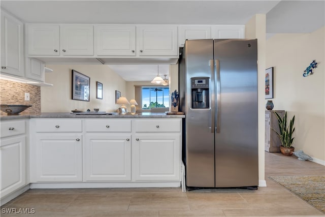 kitchen featuring white cabinets, stainless steel refrigerator with ice dispenser, and decorative backsplash