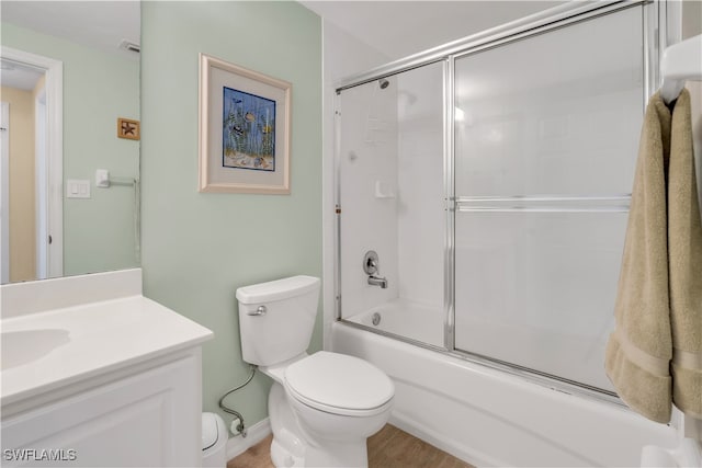 full bathroom featuring toilet, wood-type flooring, vanity, and enclosed tub / shower combo