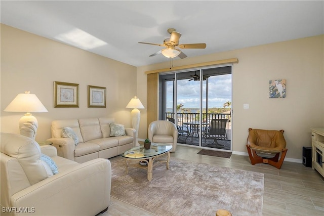 living room featuring ceiling fan and baseboards