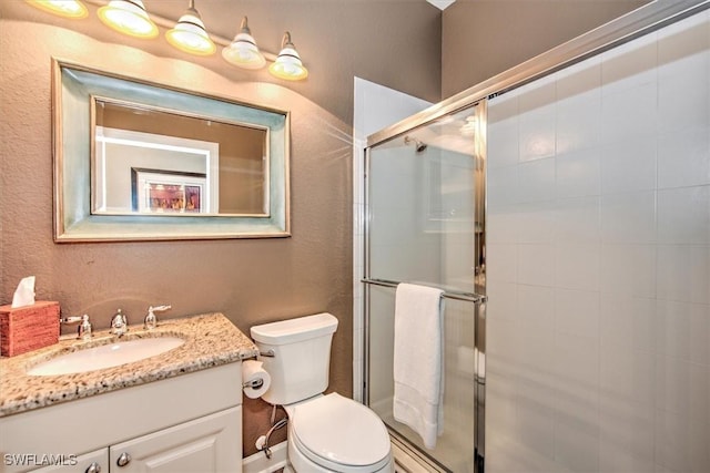 bathroom featuring vanity, toilet, and an enclosed shower