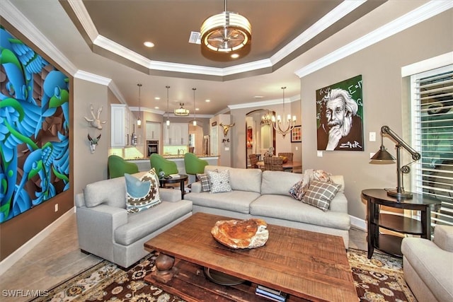 tiled living room featuring a notable chandelier, a raised ceiling, and ornamental molding