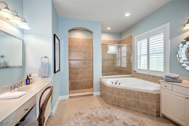 bathroom featuring tile patterned floors, vanity, and shower with separate bathtub