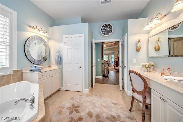 bathroom featuring tile patterned flooring, vanity, plenty of natural light, and tiled tub